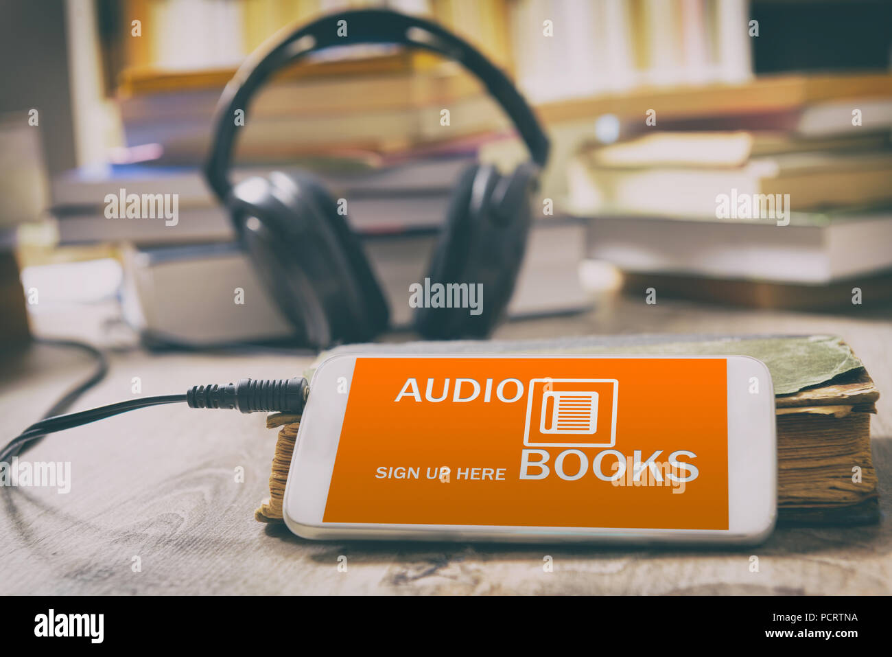 Smart phone con libri audio applicazione sullo schermo, le cuffie e la carta di libri. Concetto di ascolto di audiolibri. Foto Stock