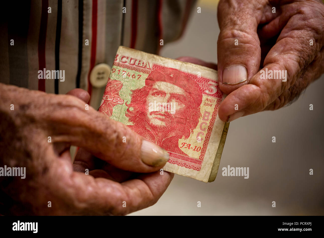 Il vecchio uomo cubano detiene una tre pesos banconota con il ritratto di Ernesto Che Guevara in mano, valuta locale, coppa, peso cubano, la povertà, La Habana, Havana, La Habana, Cuba, Cuba Foto Stock