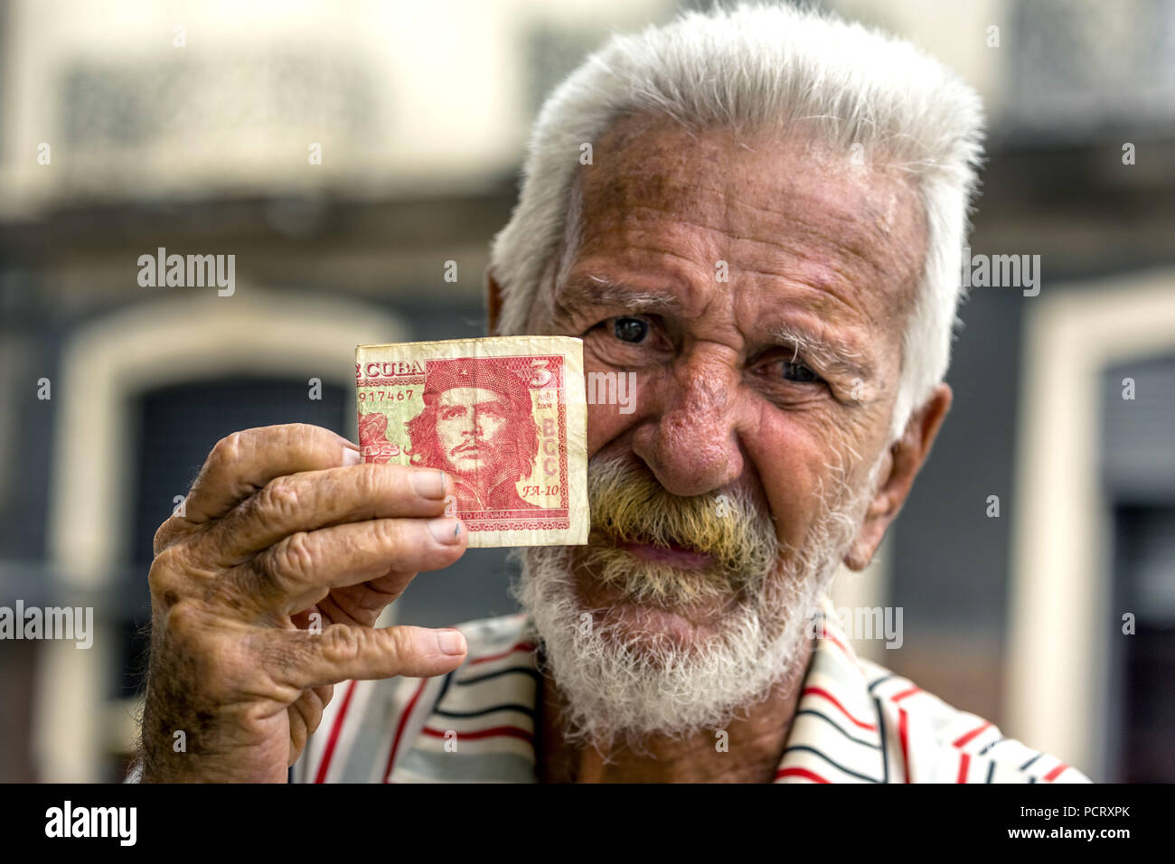 Il vecchio uomo cubano detiene una tre pesos banconota con il ritratto di Ernesto Che Guevara in mano, valuta locale, coppa, peso cubano, la povertà, La Habana, Havana, La Habana, Cuba, Cuba Foto Stock