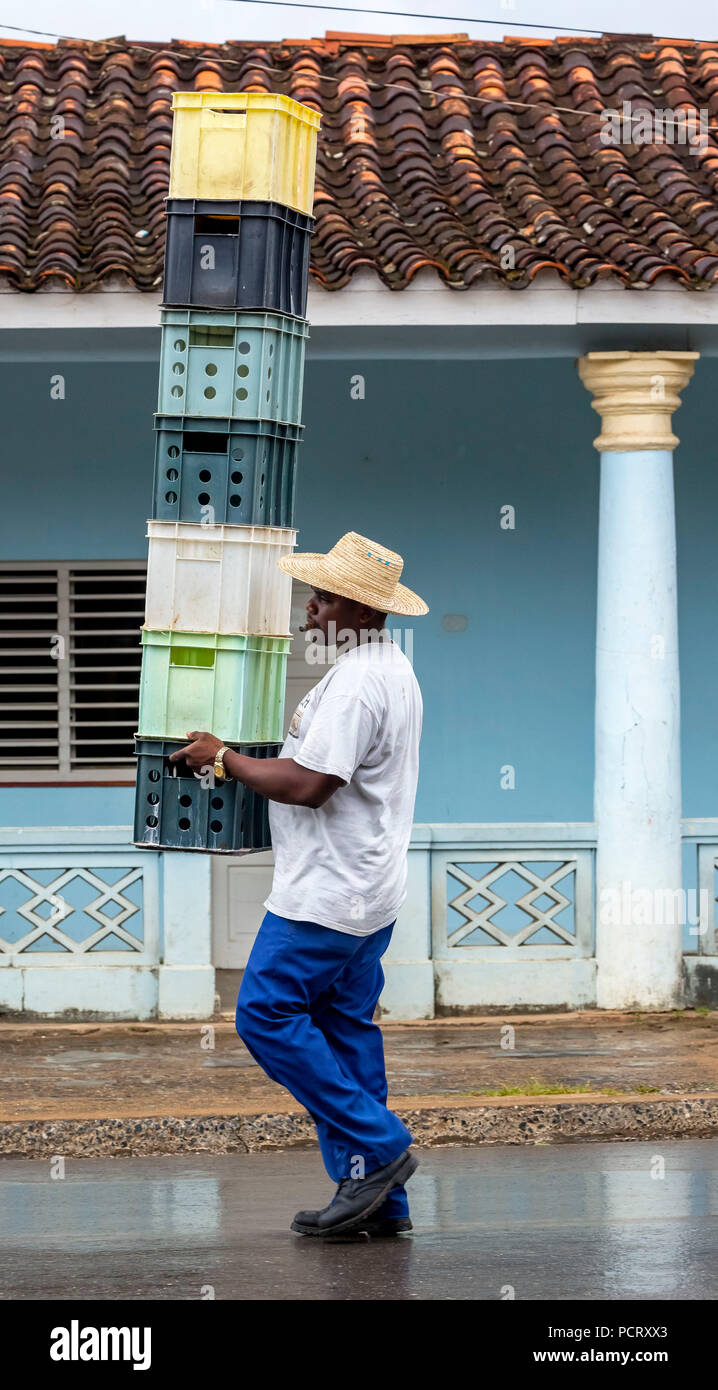 Con cubani hat i trasporti e i saldi delle casse di bevande attraverso una strada di Vinales, Viñales, Cuba, Pinar del Río, Cuba Foto Stock