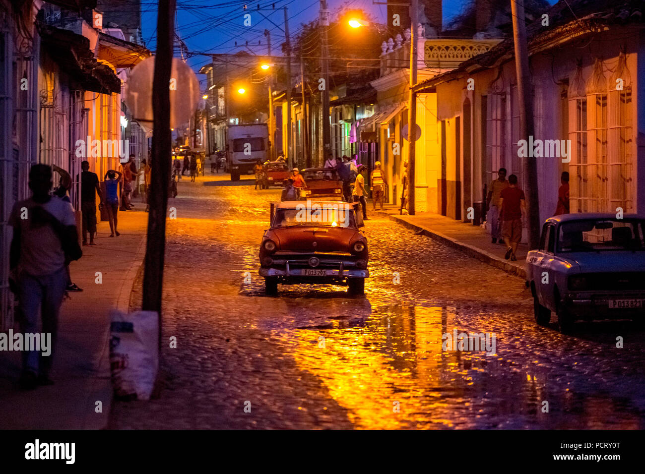 Orologio notturno scena di strada nel centro storico della città di Trinidad con auto d'epoca e lanterne, Trinidad, Cuba, Sancti Spíritus, Cuba Foto Stock