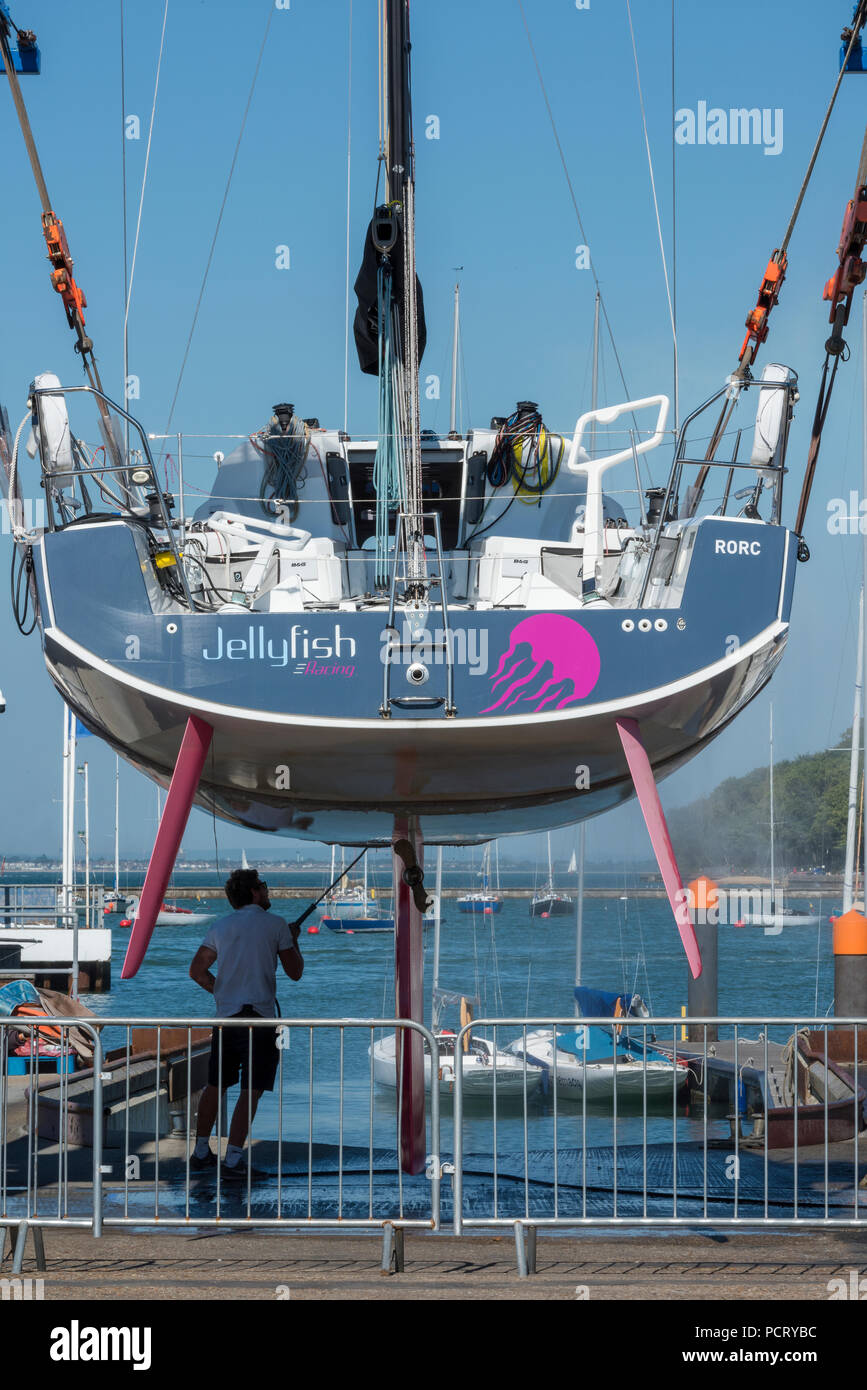 Un grande yacht racing di essere puliti con una idropulitrice a Cowes yacht  haven in una barca o un paranco sollevatore sull'isola di Wight Foto stock  - Alamy