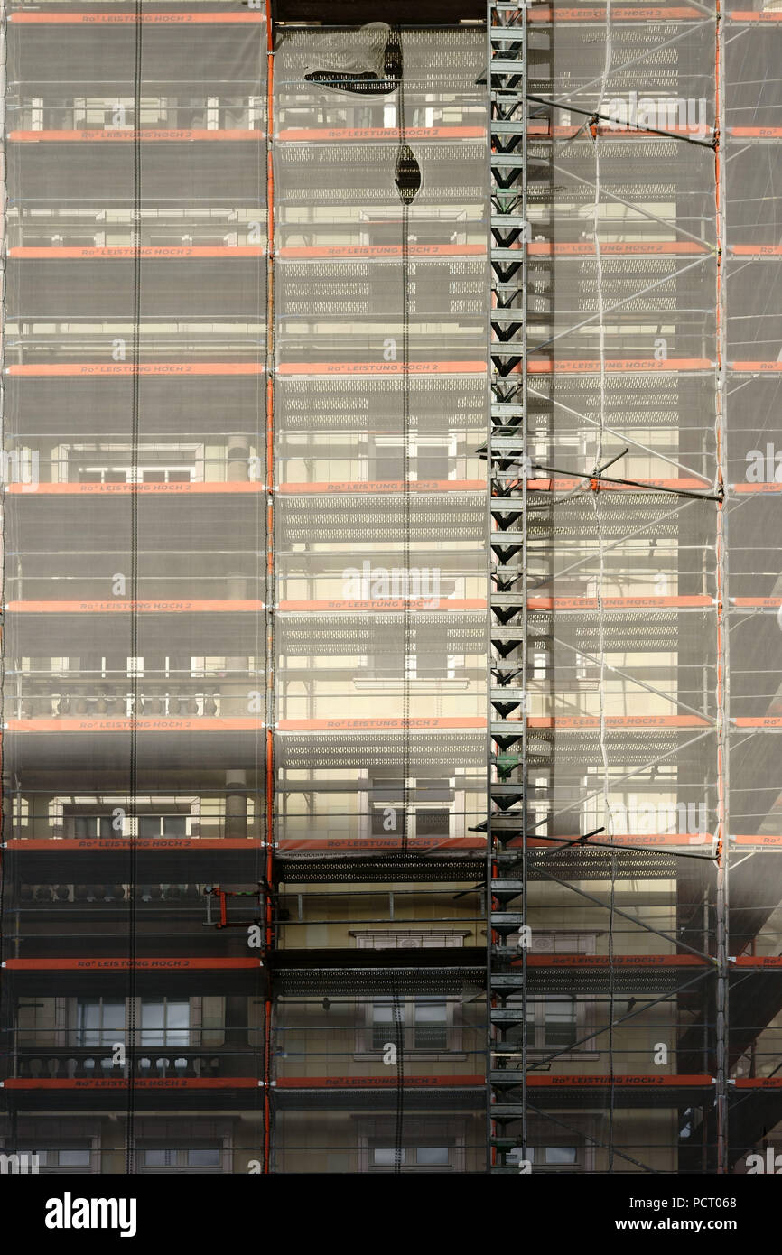 Close-up di un ponteggio con pilastri e reti di sicurezza nonché un ascensore merci Foto Stock