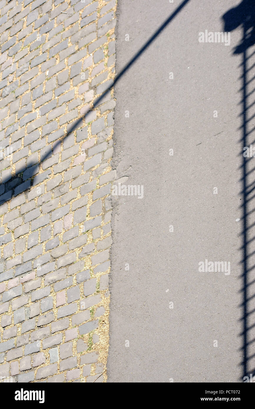 Primo piano di una passerella su un ponte il cui ringhiera proietta ombre simmetrica Foto Stock
