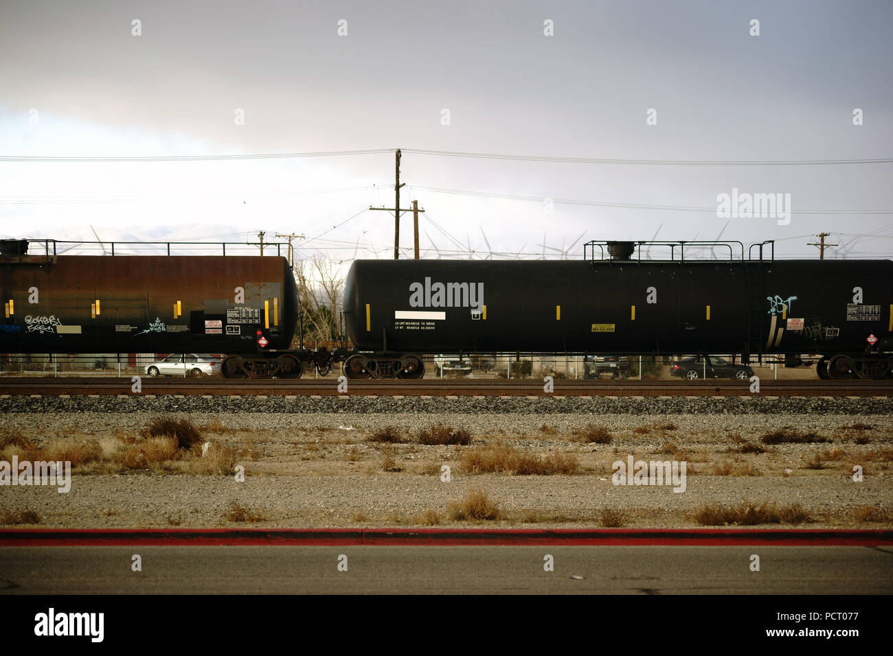 Treno merci con cisterne per il trasporto di merci pericolose per prodotti chimici liquidi sulle vie accanto a Mojave city Foto Stock
