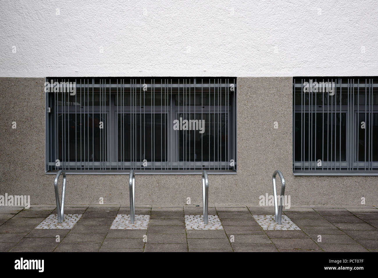 Moderno e in serie disposte Rastrelliere per biciclette in acciaio inossidabile di fronte escluso windows Foto Stock