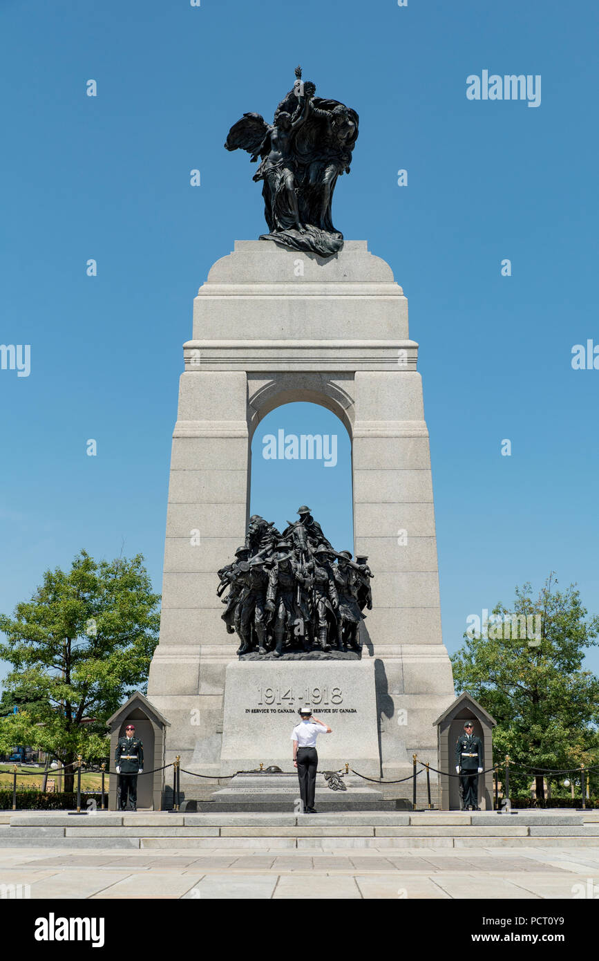 Ottawa, Ontario, Canada. Un soldato di sesso femminile che plaude al National War Memorial nella parte anteriore della tomba del Milite Ignoto, con orientamento verticale. Foto Stock