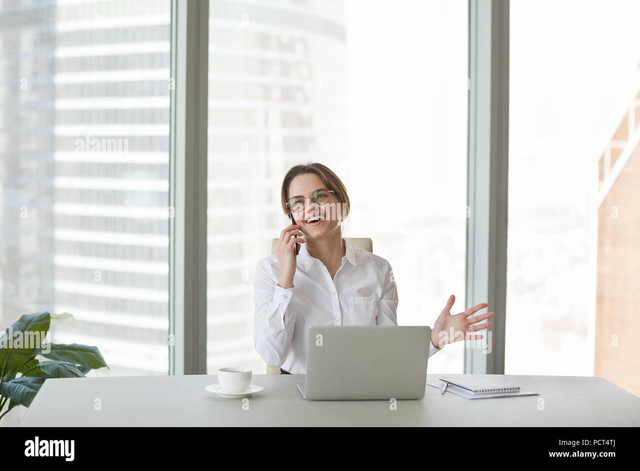 Sorridente imprenditrice felicemente a parlare al telefono con un amico Foto Stock