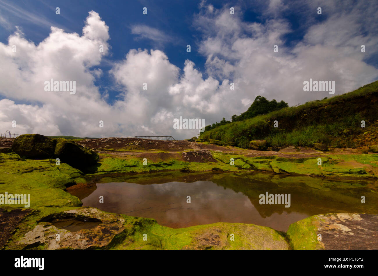 Questa è un immagine di Rocky River letto di un fiume collinare con nuvole di sfondo e riflessi sull'acqua. Foto Stock