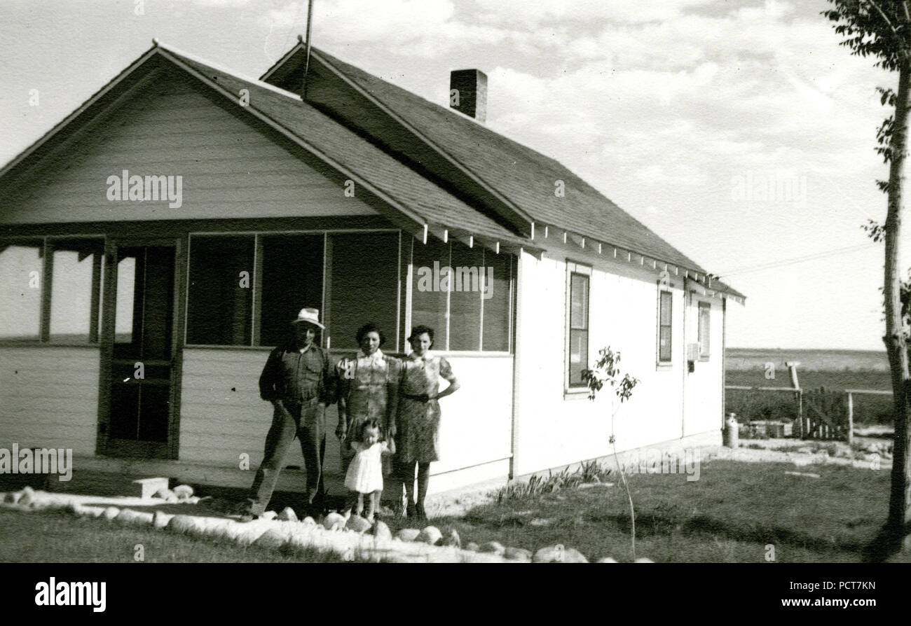 Due donne, uomo e bambino di fronte Casa 1936-1938 ca Foto Stock