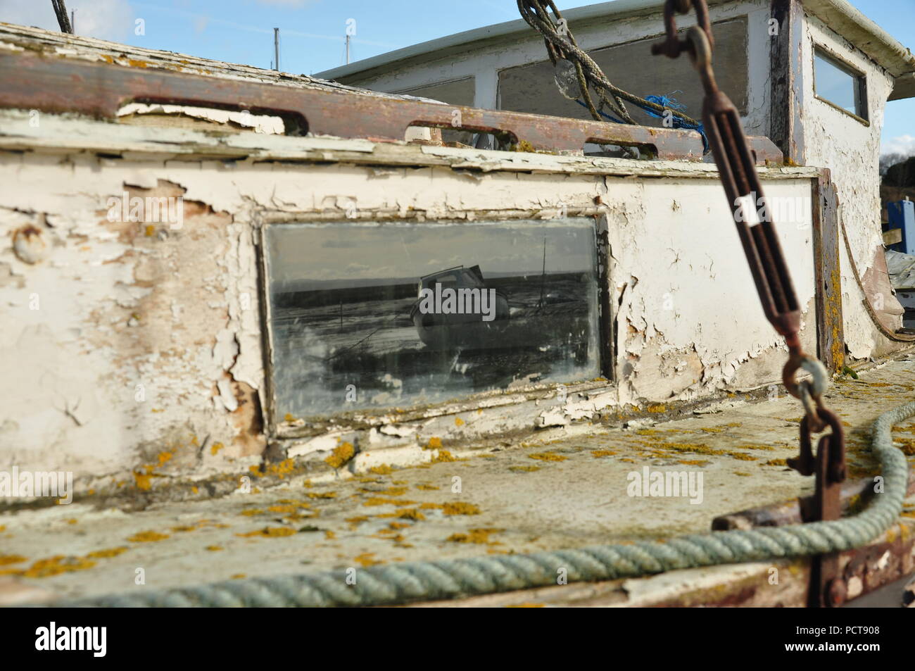 Heswall barca cimitero, barca abbandonata bloccato nel fango del dee estuario sull'Wirral vicino sheldrakes con una riflessione spettrale nella finestra Foto Stock