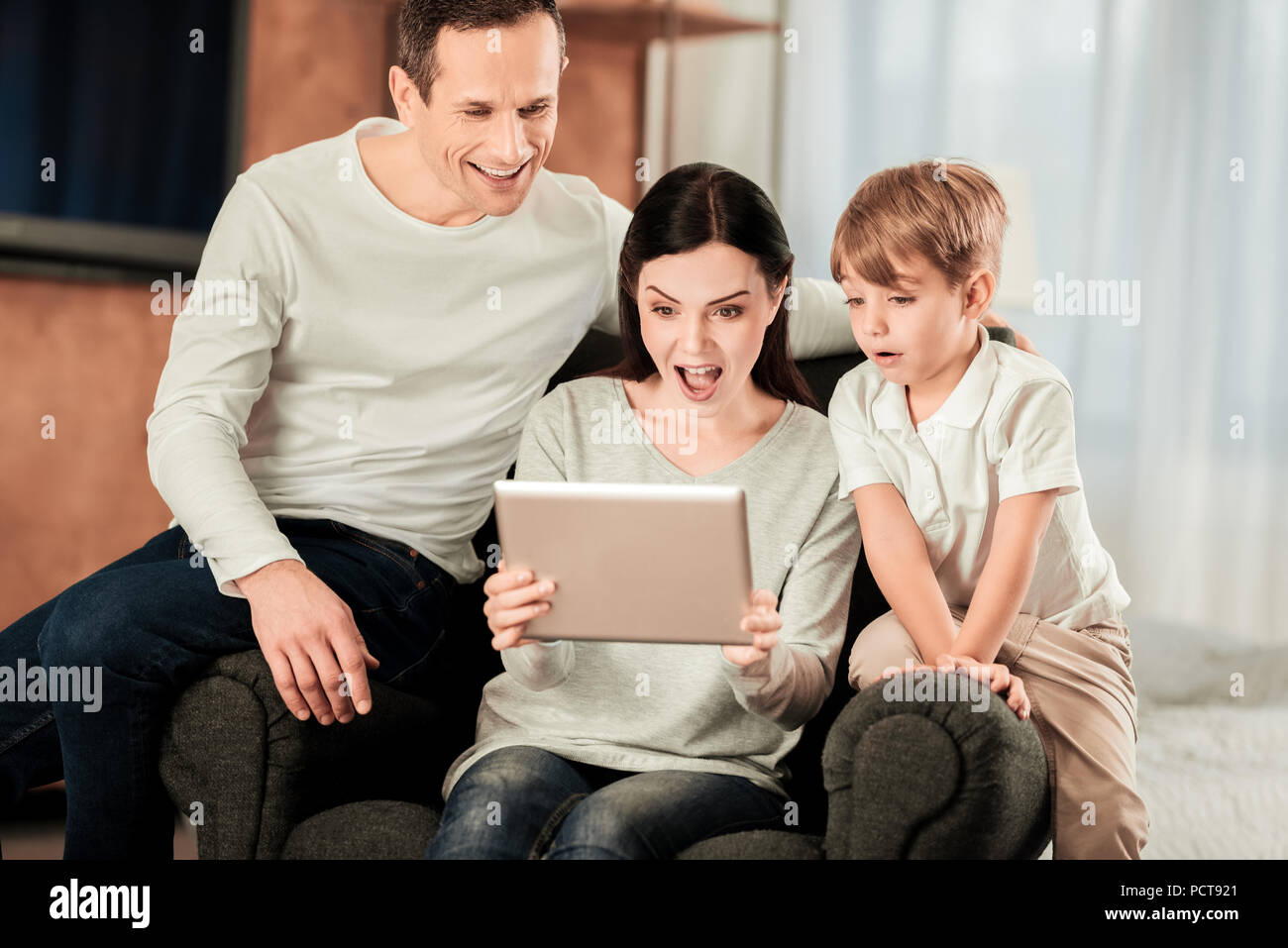 Bella sorpresa famiglia guardando lo schermo di tablet Foto Stock