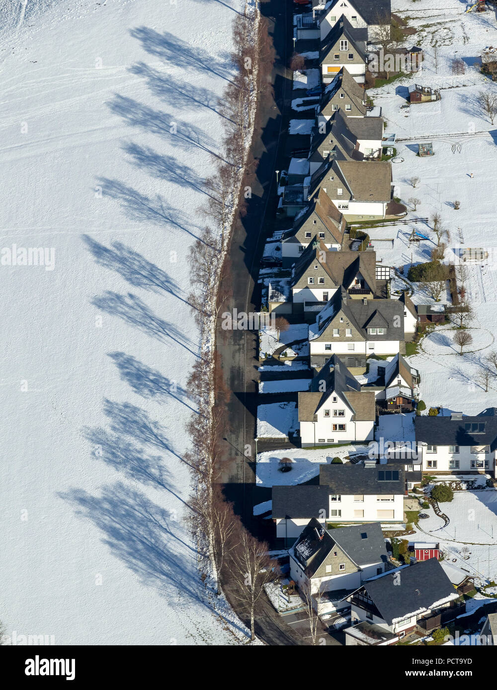 Kirchstraße, strada residenziale con case su un lato e le ombre degli alberi, neve, Holthausen, vista aerea di Schmallenberg, Sauerland Foto Stock