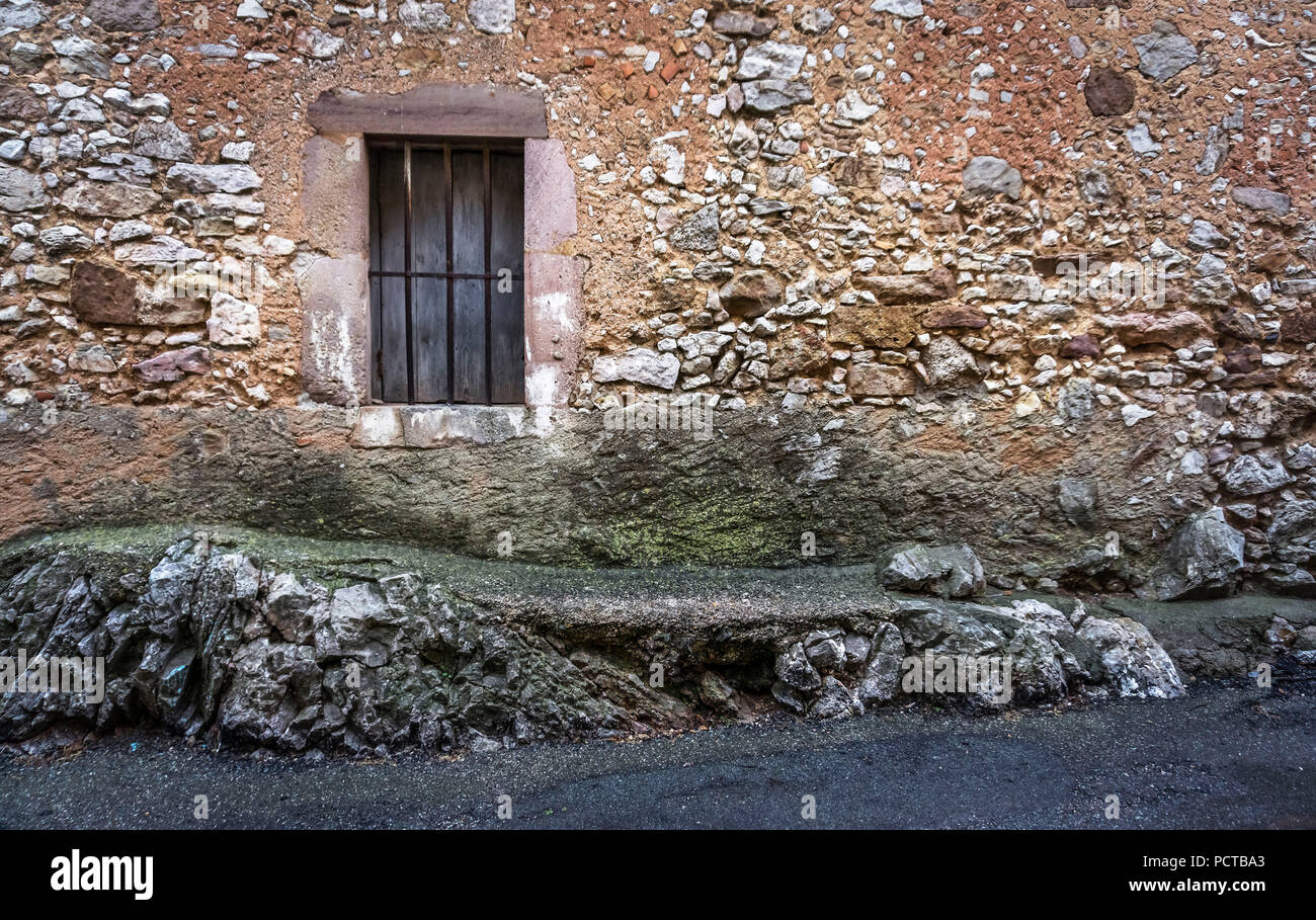 Muro di pietra con finestra, costruito sulle rocce Foto Stock