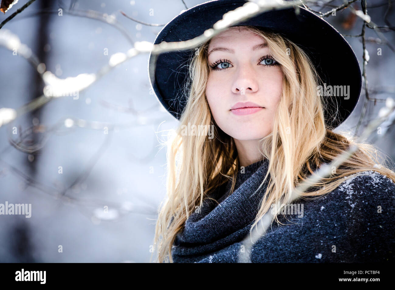 Giovane donna all'aperto, vestito invernale, cercando open-minded presso la fotocamera Foto Stock