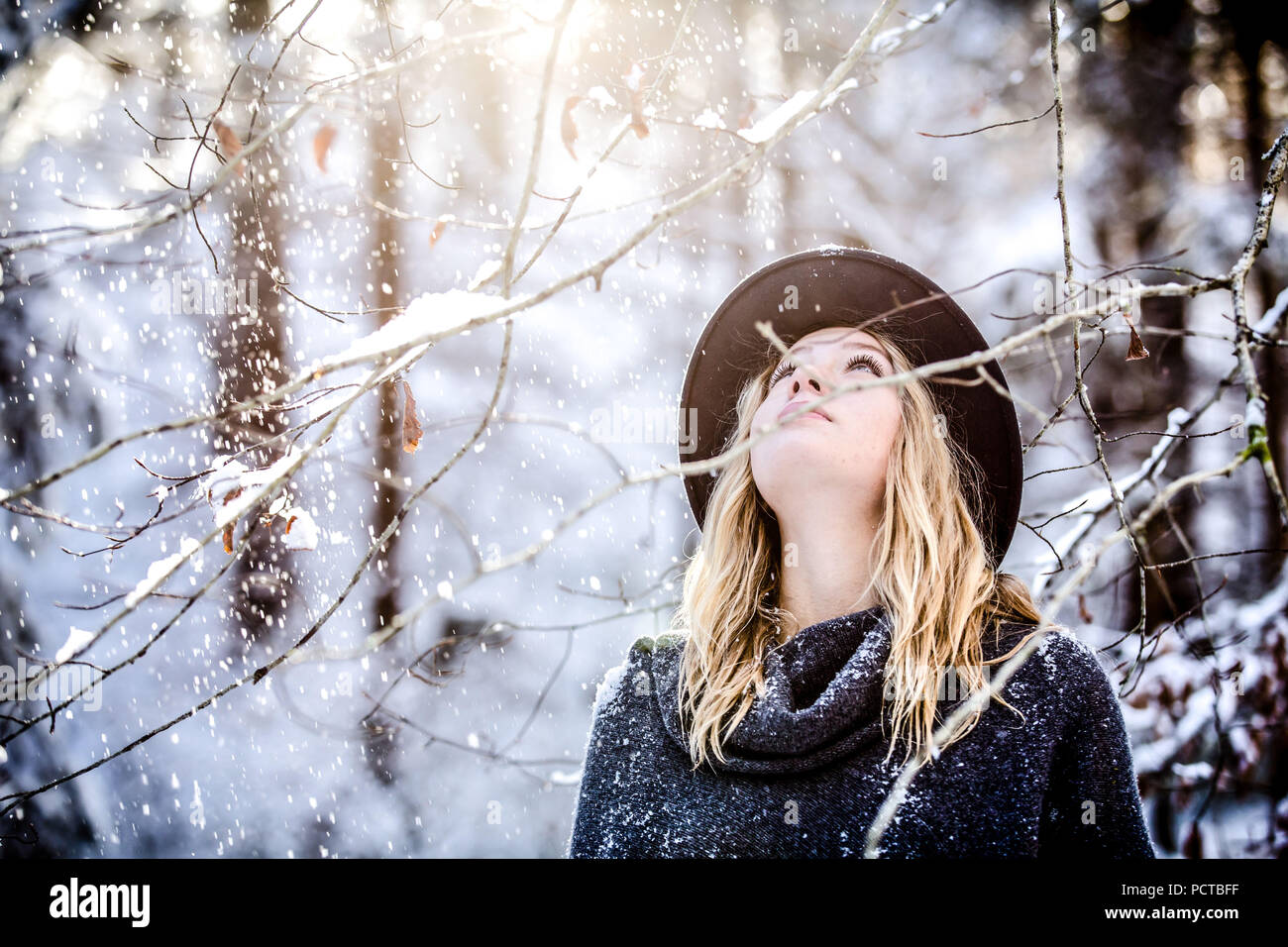 Giovane donna con capelli biondi vestito invernale, guardando verso l'alto Foto Stock