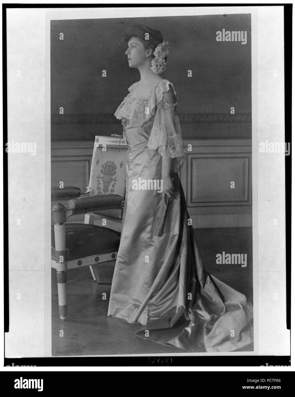 Alice Roosevelt Longworth, ritratto a figura intera, in piedi accanto alla sedia, rivolto verso sinistra Foto Stock