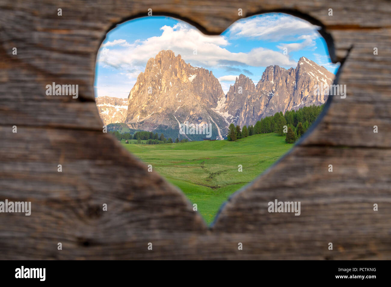 L'Europa, l'Italia, Bolzano, Alto Adige Alpe di Siusi - Alpe di Siusi Dolomiti del gruppo del Sassolungo / Sassolungo visto dall alpe di Siusi / Seiser Alm attraverso un cuore-finestra sagomata Foto Stock