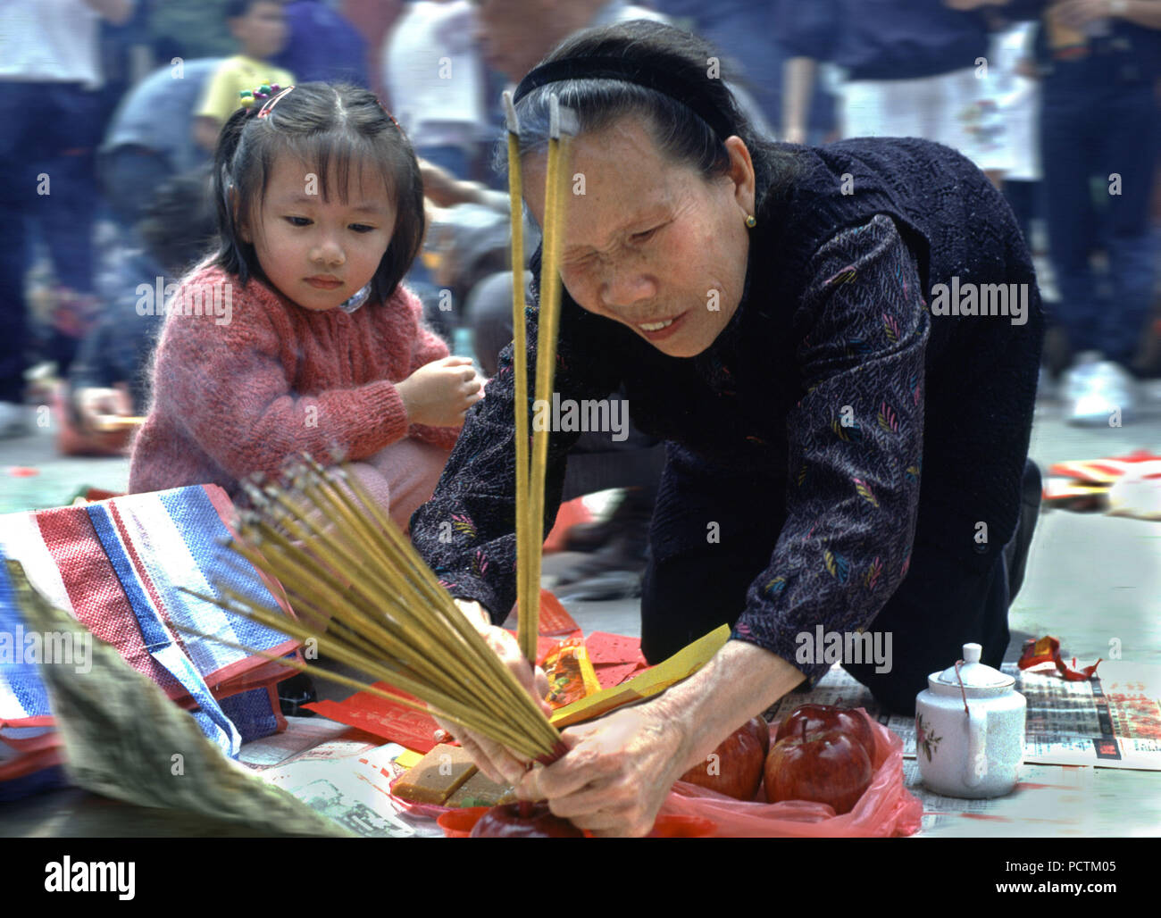 Donna e bambino facendo rituali in ha vinto il peccato Tai tempio, Hong Kong, Cina, Asia Foto Stock
