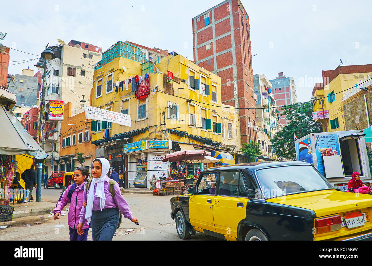 Alessandria, Egitto - 18 dicembre 2017: La scena urbana nel distretto di Karmouz - il vecchio squae mercato con negozi e bancarelle, alla guida di taxi e i bambini, andare Foto Stock