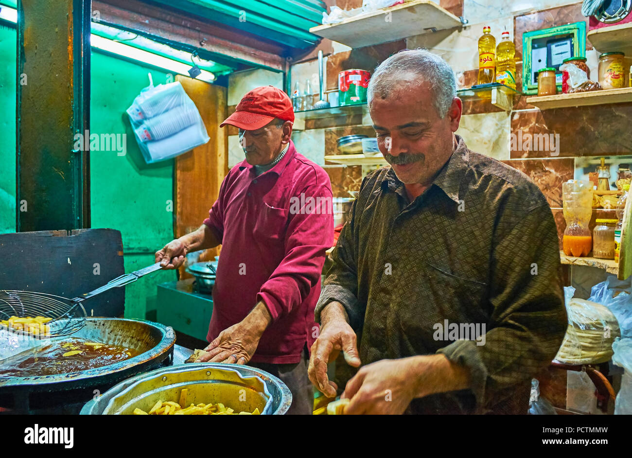 Alessandria, Egitto - 18 dicembre 2017: Il piccolo caffè nel Souq At-Tork con cucina aperta, dove i cuochi senior prepair patatine fritte e altri str Foto Stock