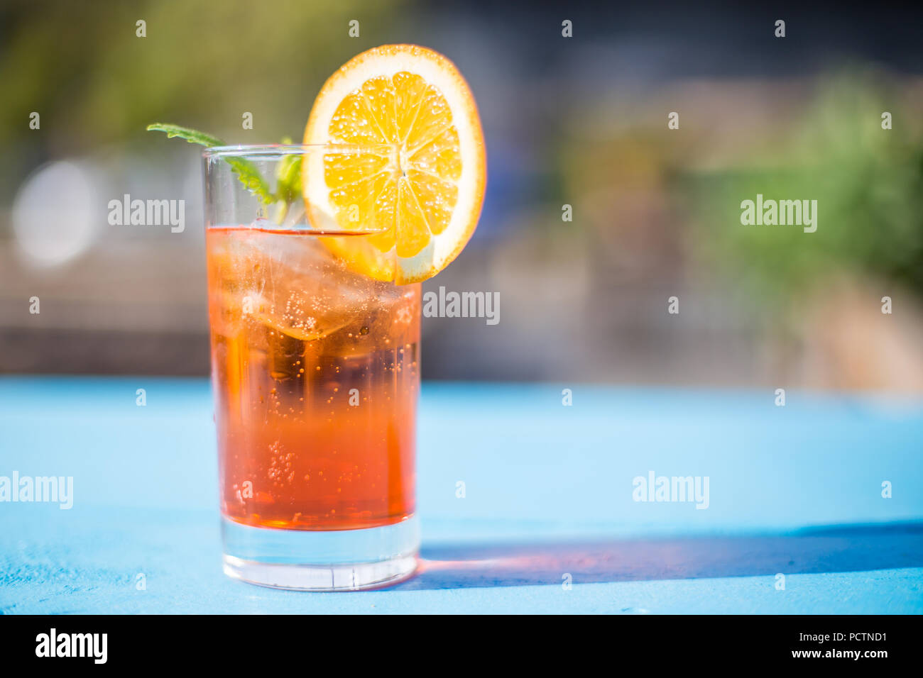 Bicchiere di aperol spritz con la menta e una fetta di arancia in una giornata di sole. Foto Stock