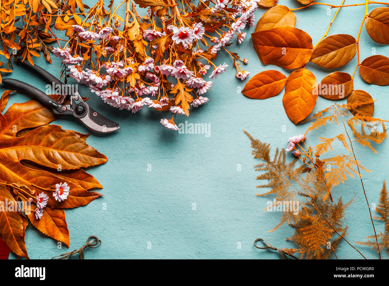 Autunno decorazioni di fiori e fiori disposizione con sfondo giallo di  foglie e fiori di colore rosa sul turchese desktop , vista dall'alto. In  autunno il lavoro di fiorista Foto stock -