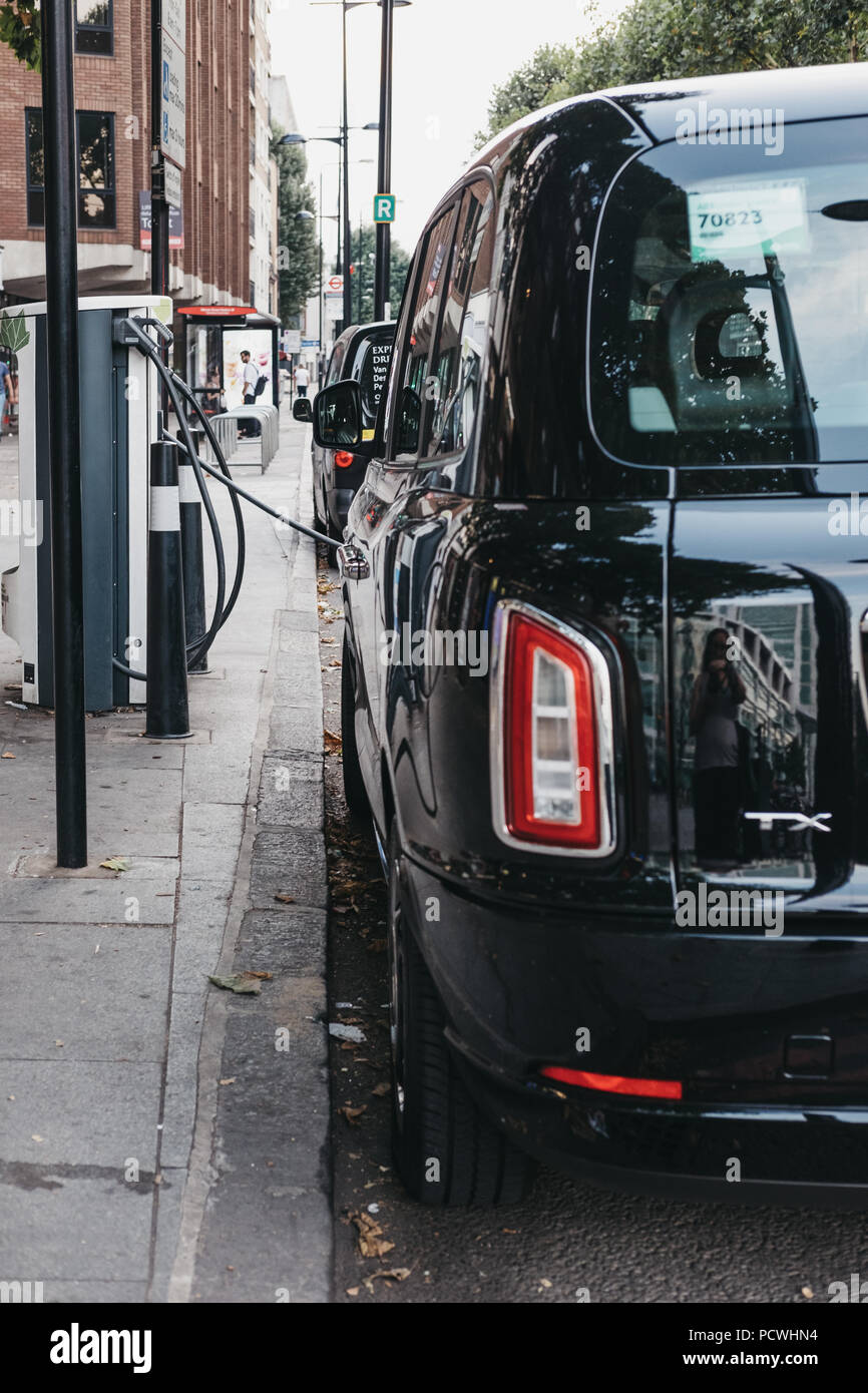 Nuovo LEVC elettrico TX London Black Cab ricarica dal punto di modifica su una strada di Londra, Regno Unito. Foto Stock