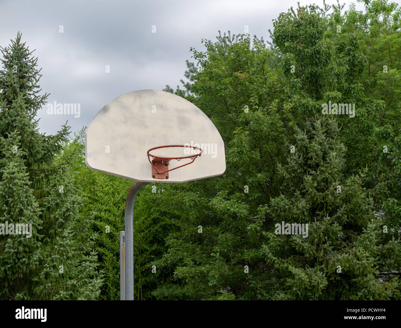 Rundown acciaio Basketball hoop manca la sua rete su nuvoloso giorno Foto Stock