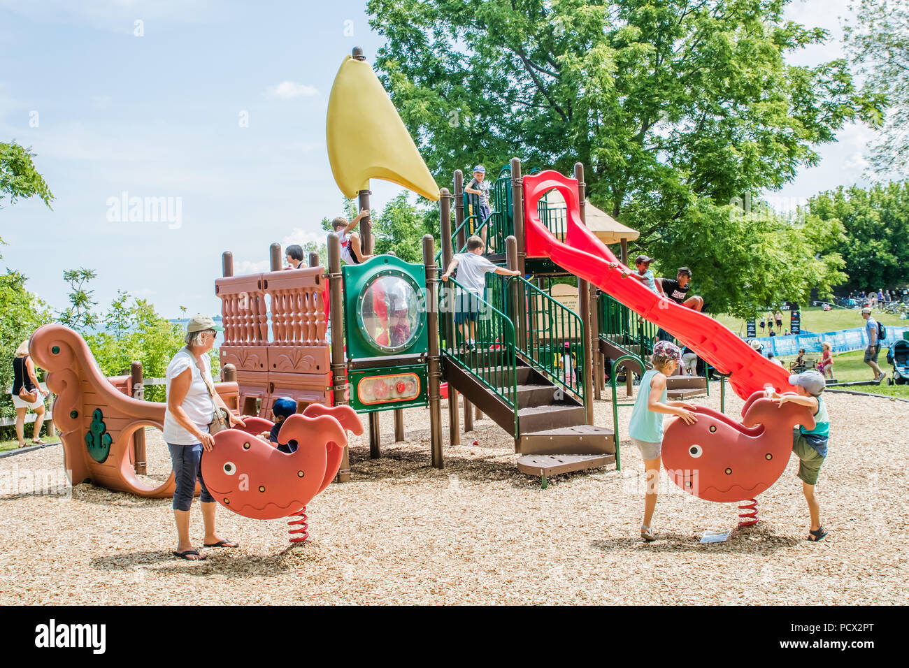 Giovani bambini che giocano nel parco giochi all'aperto in estate Foto Stock