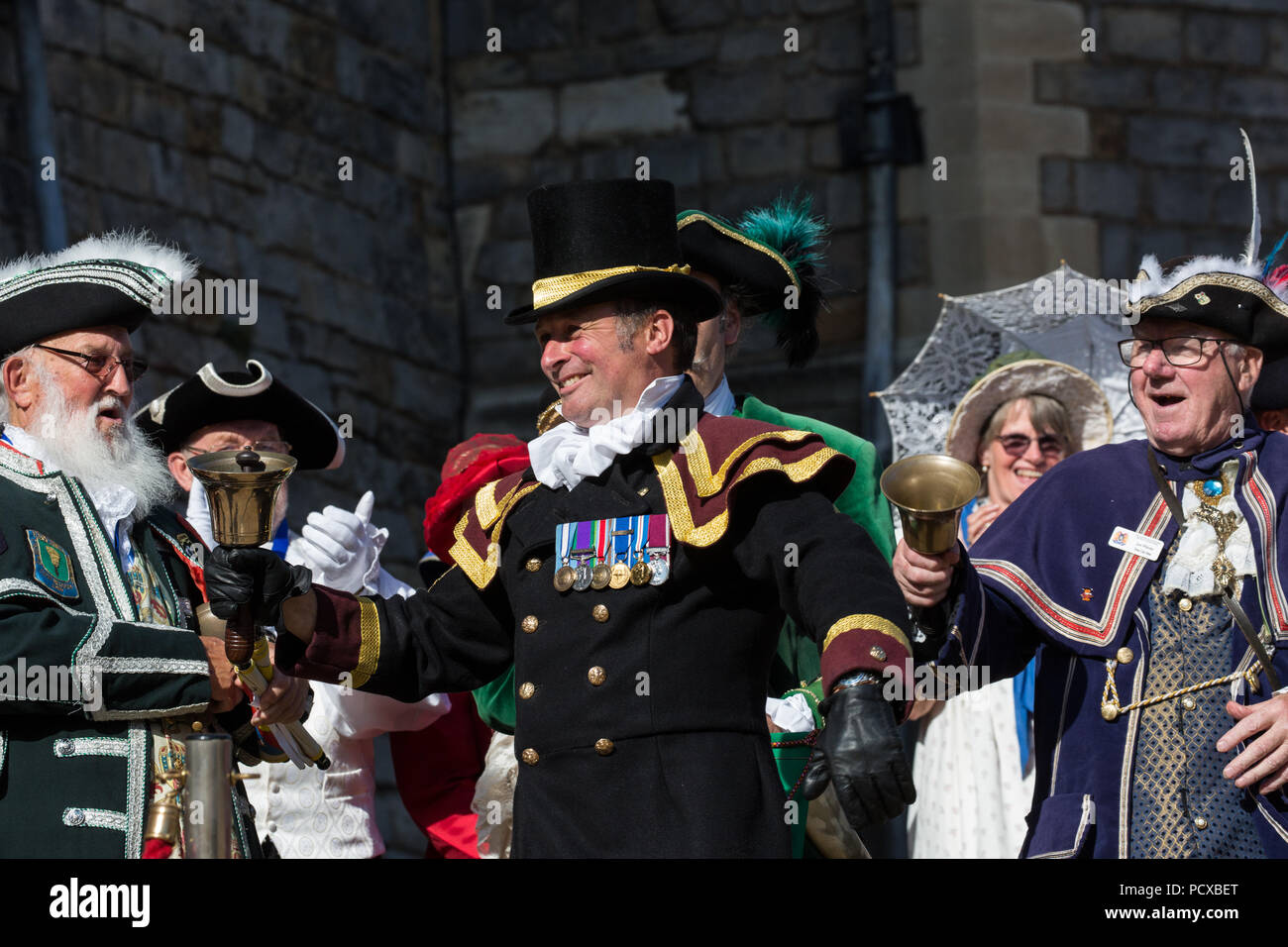 Windsor, Regno Unito. 4° agosto 2018. Christian Ashdown, Town Crier di Haslemere, vince il primo premio all'antica e onorevole Guild of Town Criers (AHGTC) Campionato Nazionale sotto le mura del Castello di Windsor. Quaranta criers da tutto il Regno Unito e due australiani hanno gareggiato in due turni di pianto, il primo un grido iniziale segnato sulla dizione, flesso, la chiarezza e il volume e la seconda un grido sul tema di "Una celebrazione". Credito: Mark Kerrison/Alamy Live News Foto Stock