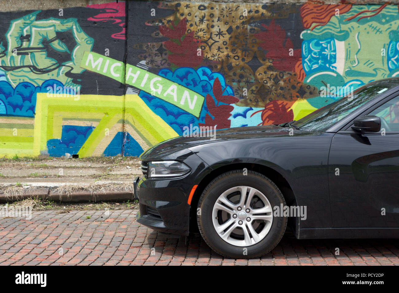 DETROIT, Michigan, Stati Uniti - 22 Maggio 2018: Nero Dodge Charger di fronte a un muro con graffiti nel centro di Detroit Foto Stock