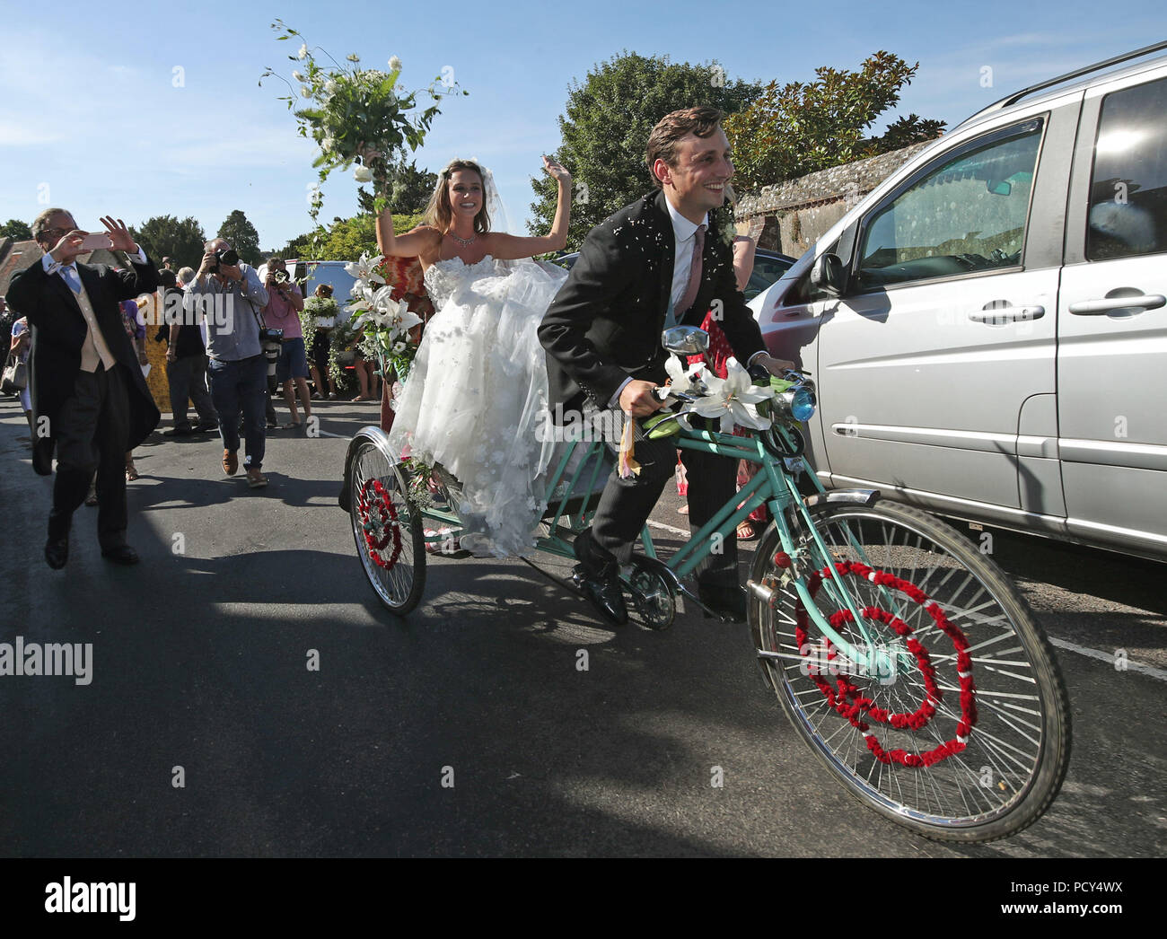 Charlie van Straubenzee cavalca un triciclo con la sua sposa Daisy Jenks  nel sedile del passeggero al di fuori di Santa Maria Vergine Chiesa in  Frensham, Surrey, dopo il loro matrimonio Foto