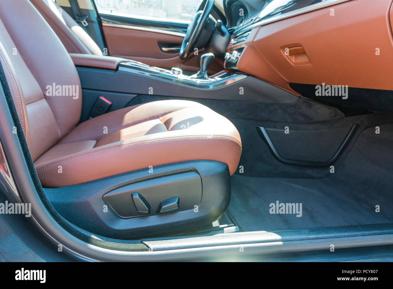 Vista laterale di un'auto di lusso passeggero anteriore sedile in pelle con potenza i pulsanti di controllo. Foto Stock