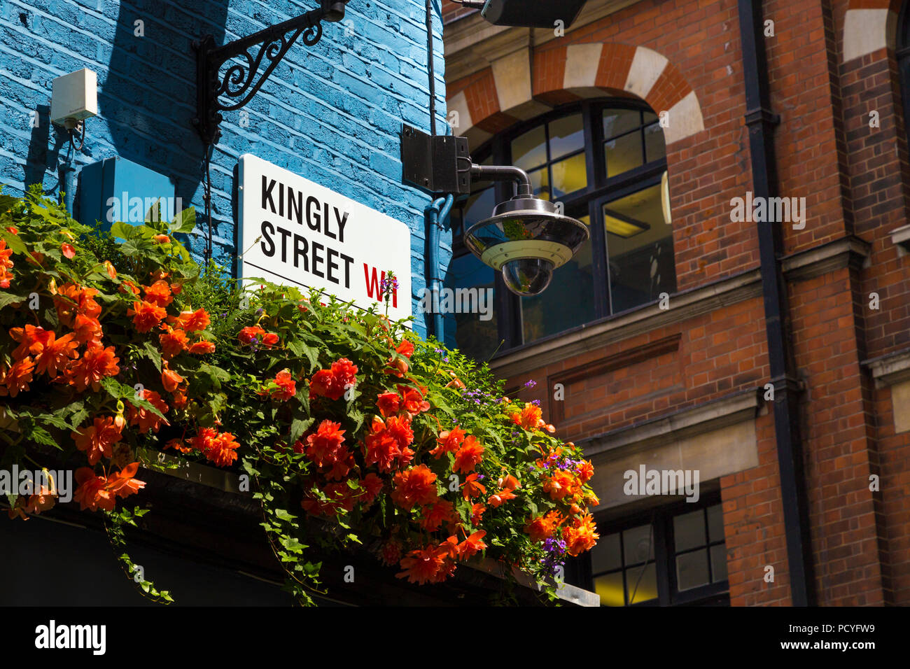 Segno per strada regale su un dipinto di blu un muro di mattoni, edificio decorato con fiori, Carnaby, London, Regno Unito Foto Stock