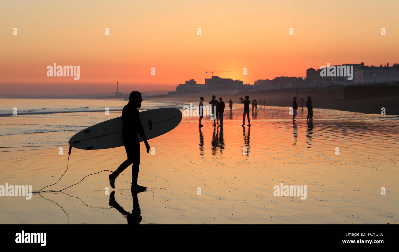 I riflessi del tramonto sulla spiaggia al tramonto, durante la bassa marea a Brighton Foto Stock