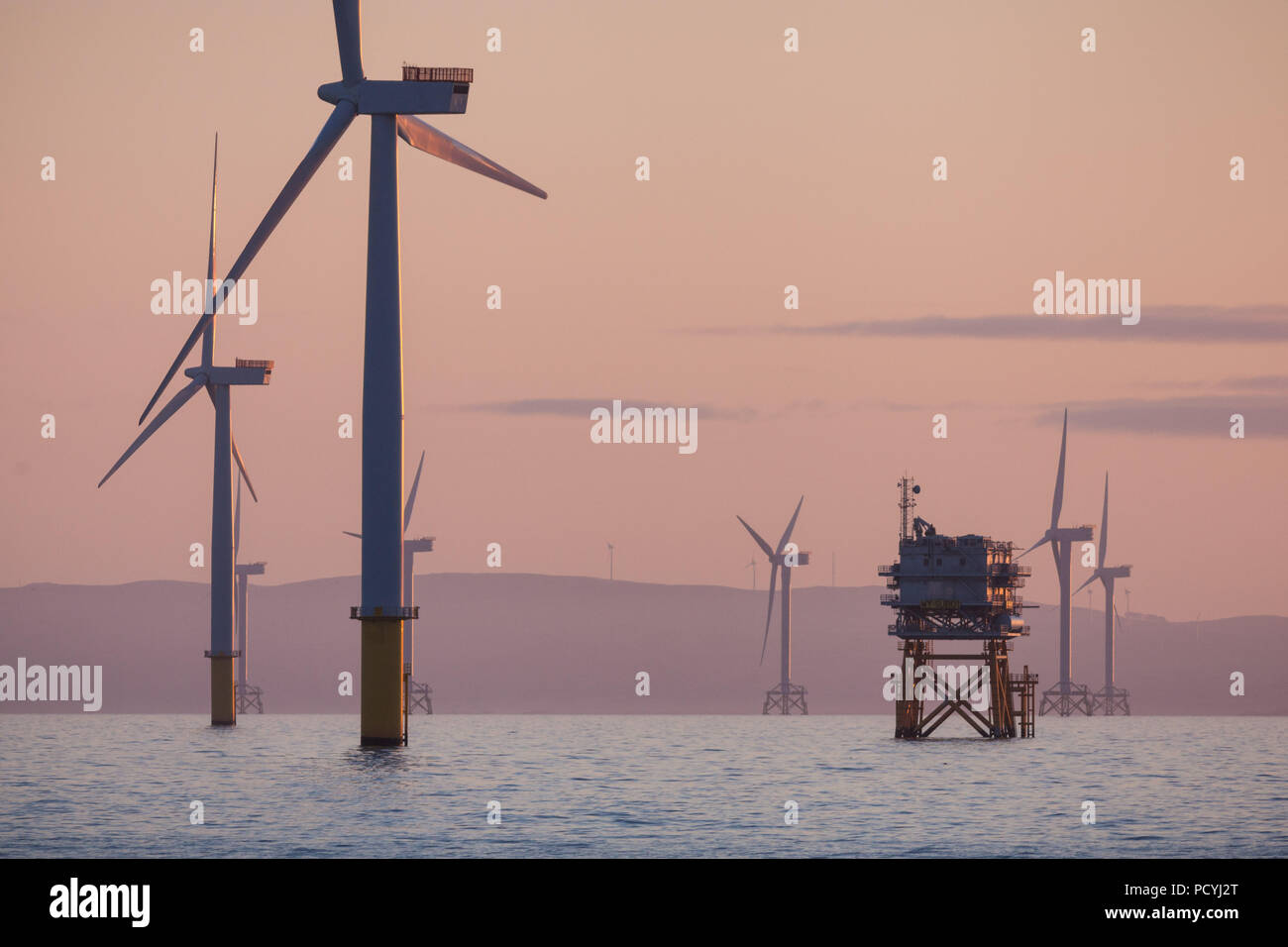 Sulle turbine eoliche offshore su Walney Offshore Wind Farm all'alba nel mare d'Irlanda, Regno Unito Foto Stock