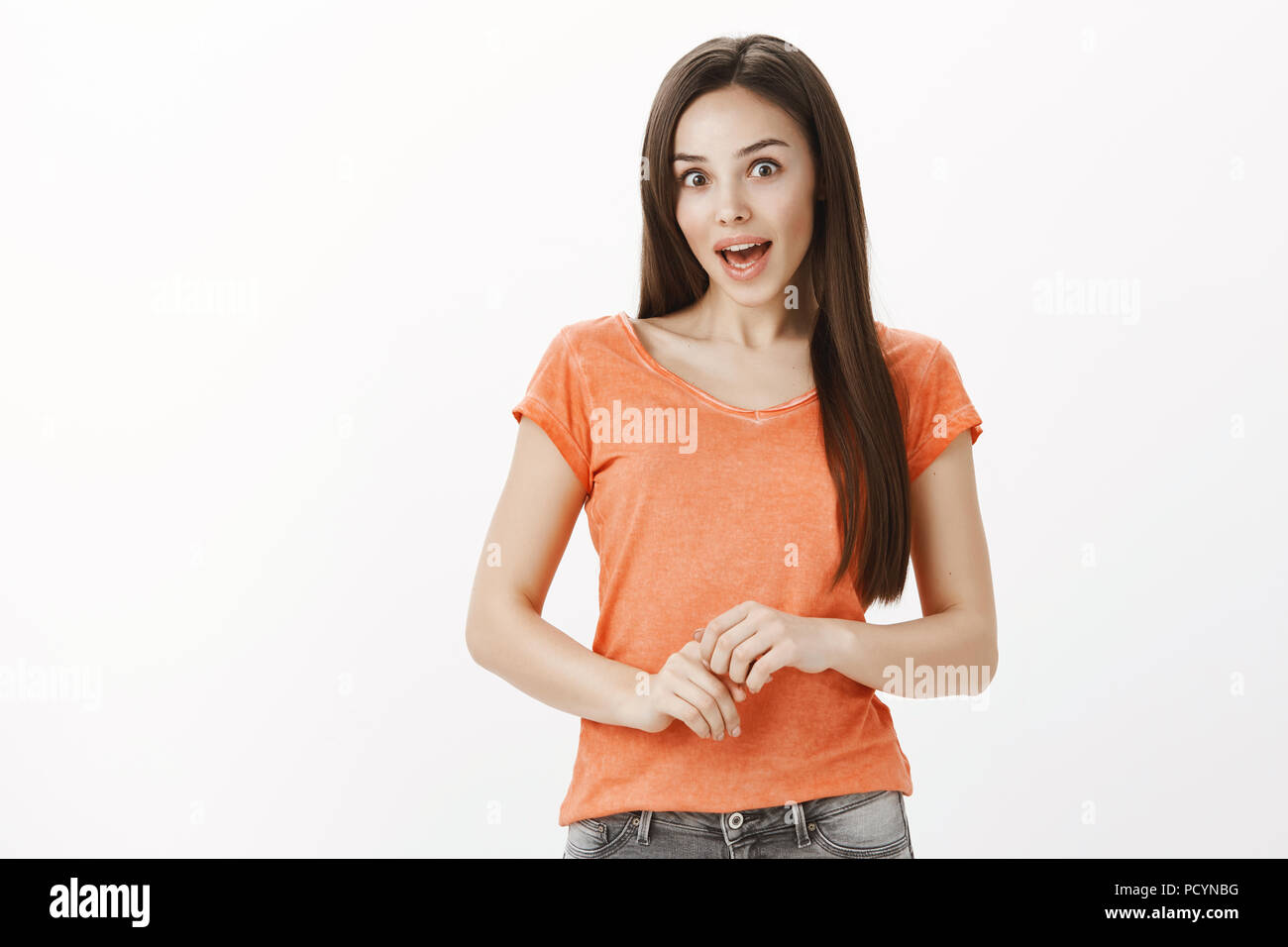 Piscina ritratto di chiesti donna attraente in t-shirt casual, strofinando le mani vicino al ventre e parlando casualmente con un collega, essendo eccitato e interessa. Foto Stock