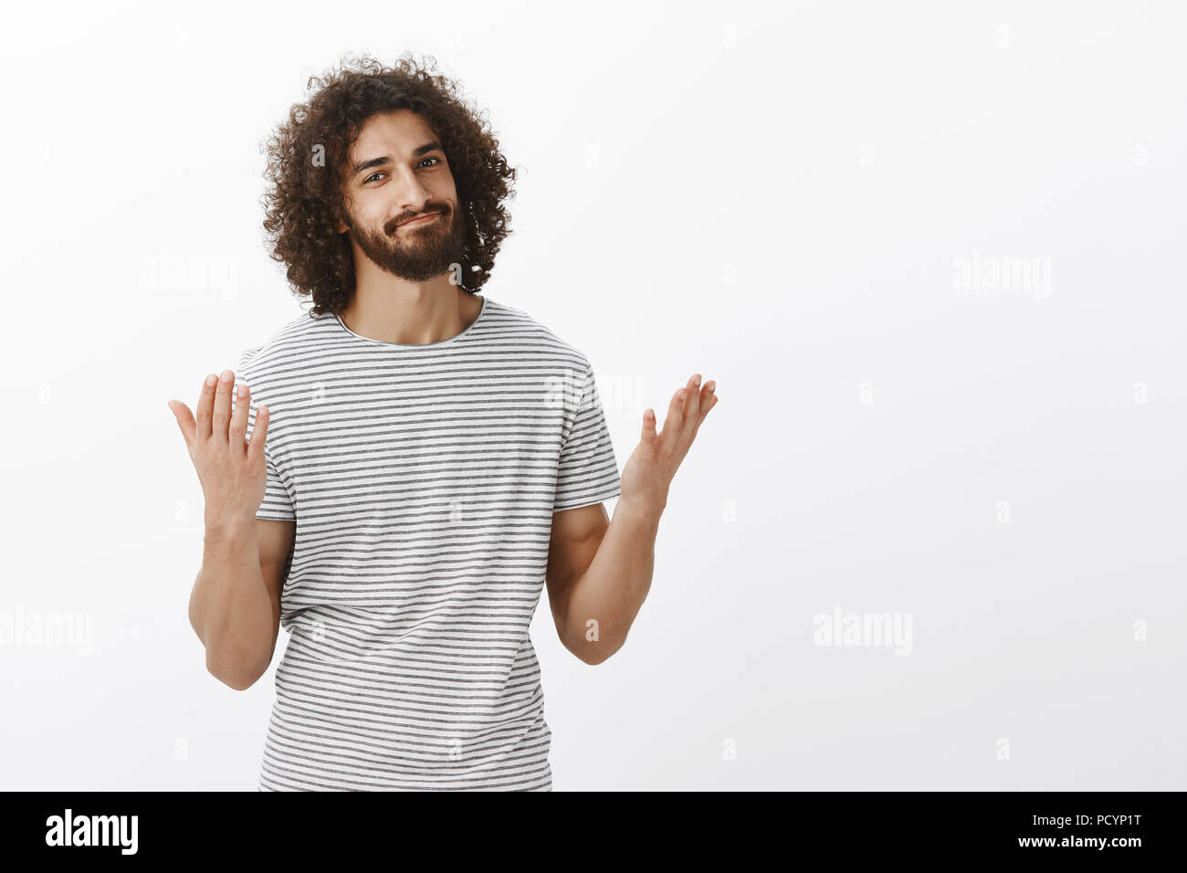 Ti ha detto che avevo ragione. Bello orientale modello maschio con la barba e capelli ricci, alzando le mani e smirking, essendo alleggerita e dire infine, in attesa fo Foto Stock