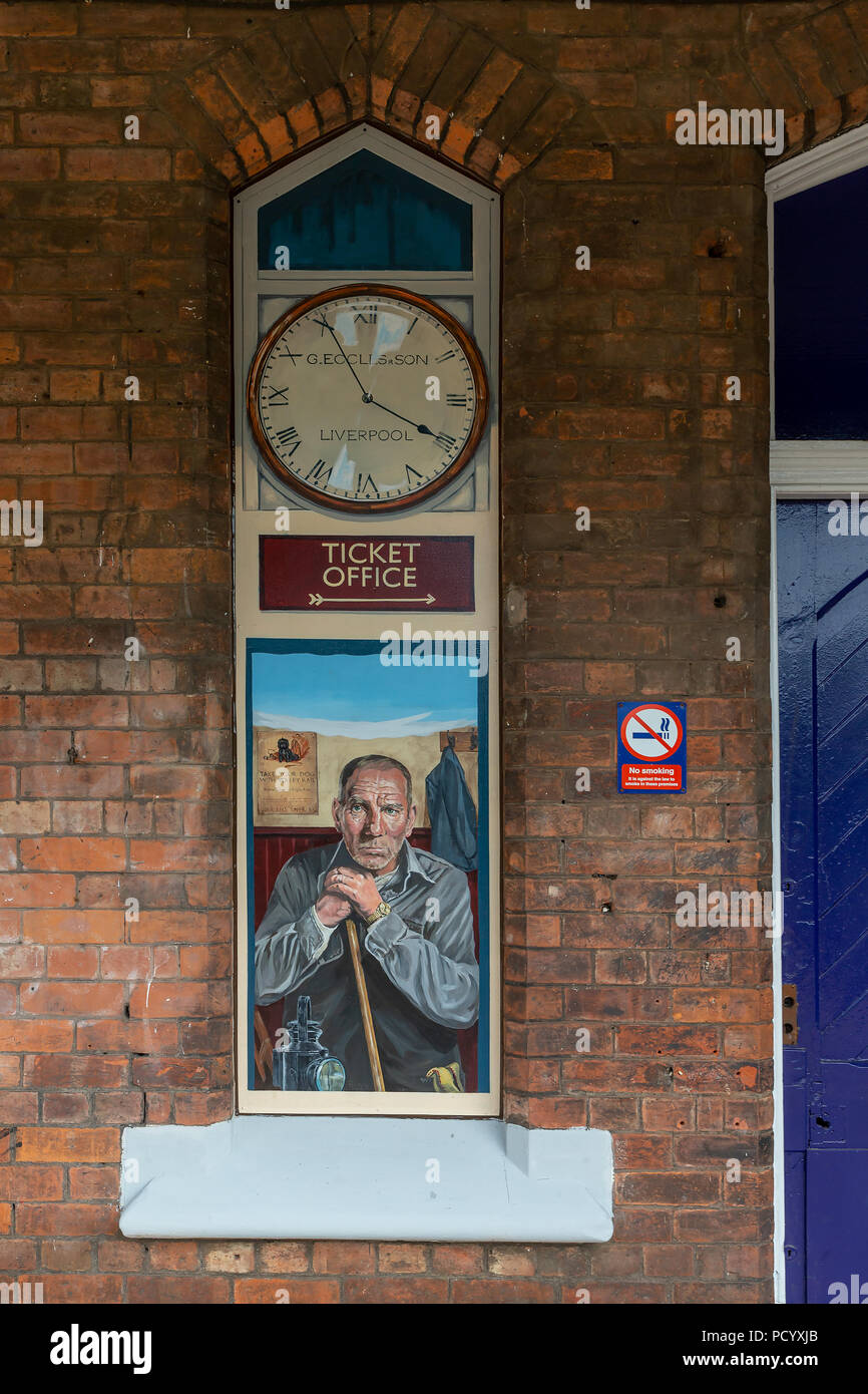 Un non più utilizzati nella finestra edificio presso la storica stazione ferroviaria di Padgate ha una pittura di carattere locale attore, Pete Postlethwaite, Warrin Foto Stock