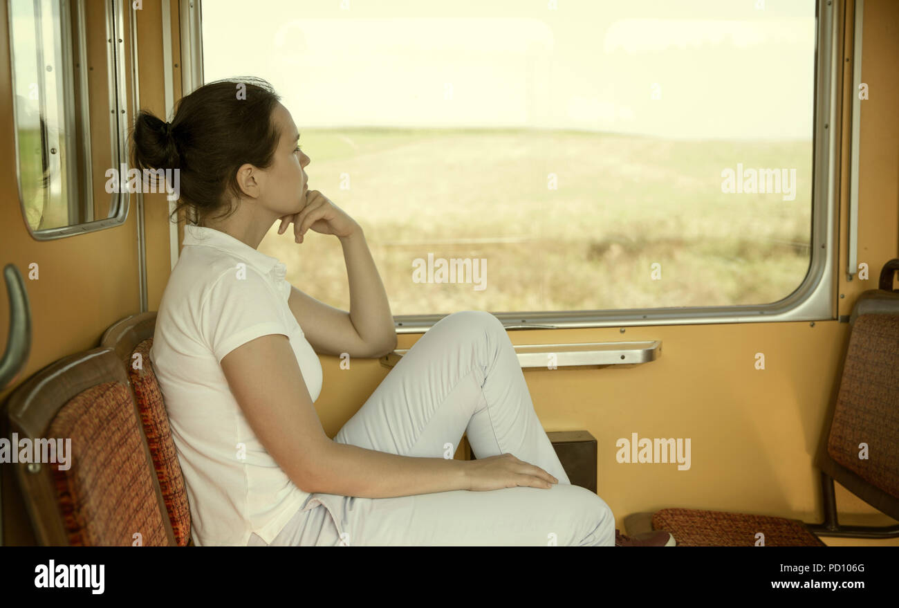 Giovane donna pensieroso in un treno vintage Foto Stock