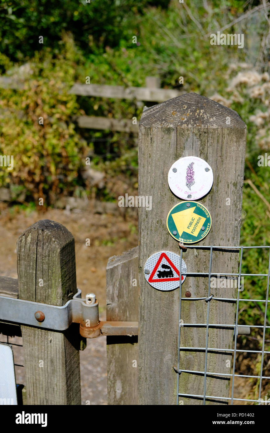 Scudetti su un palo di legno punto il modo per la East Devon modo sentiero pubblico a Exmouth, Devon, Inghilterra, Regno Unito Foto Stock