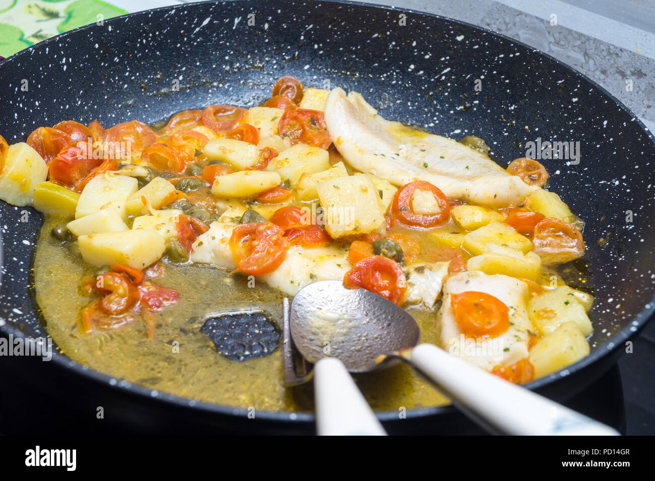 Il merluzzo cotto in padella con pomodoro, Patate e Capperi Foto Stock