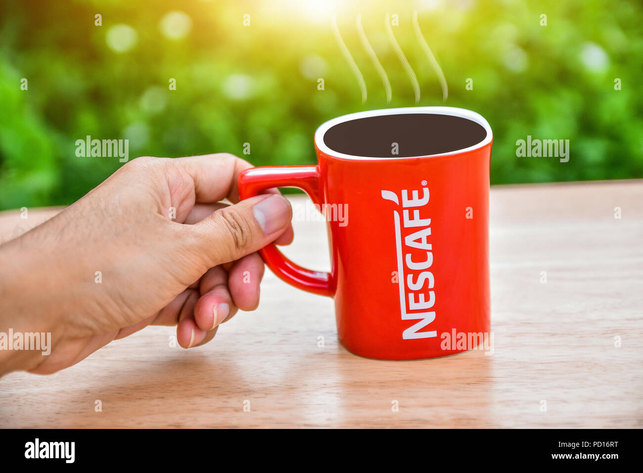 Bangkok, Tailandia - 5 Agosto 2018: Nescafe red tazza di caffè sul tavolo  in legno con natura verde dello sfondo Foto stock - Alamy