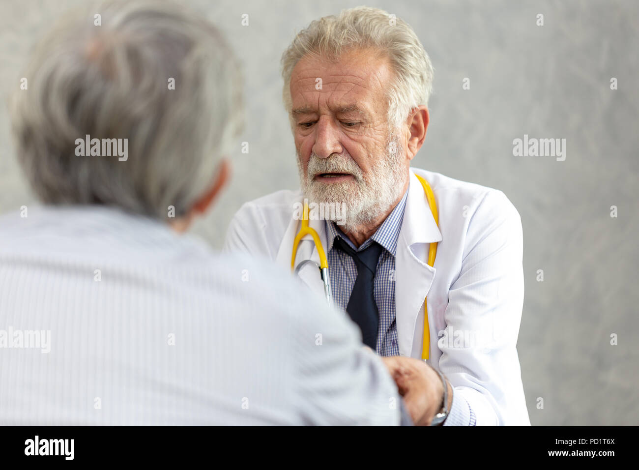 Senior di medico o di medico capo dando una consultazione per il suo paziente di sesso maschile e spiegando le informazioni mediche e diagnosi presso la clinica o hos Foto Stock