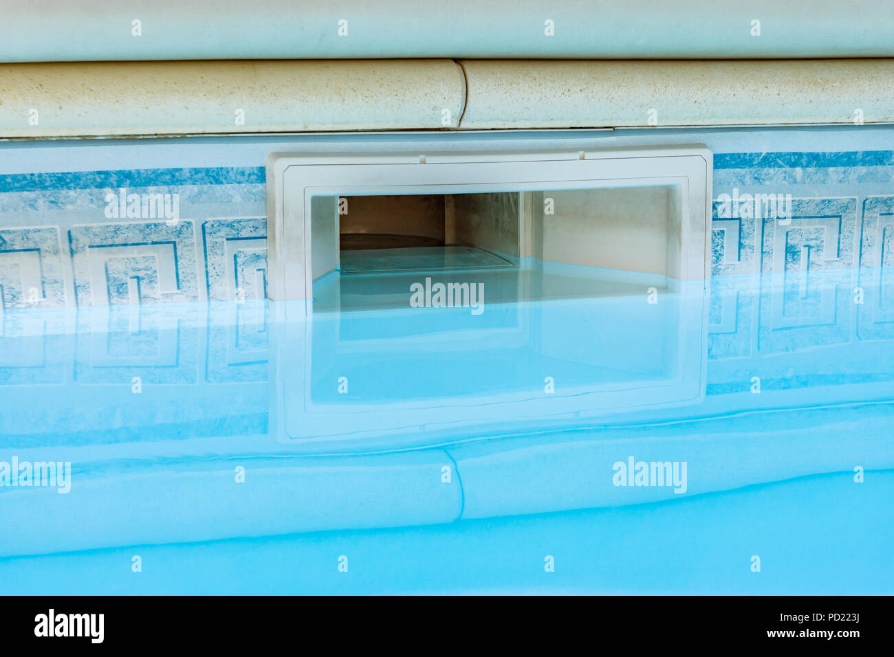 Parete attrezzature skimmer filtrazione piscina con sistema di riflessione sulle acque blu della piscina. Foto Stock