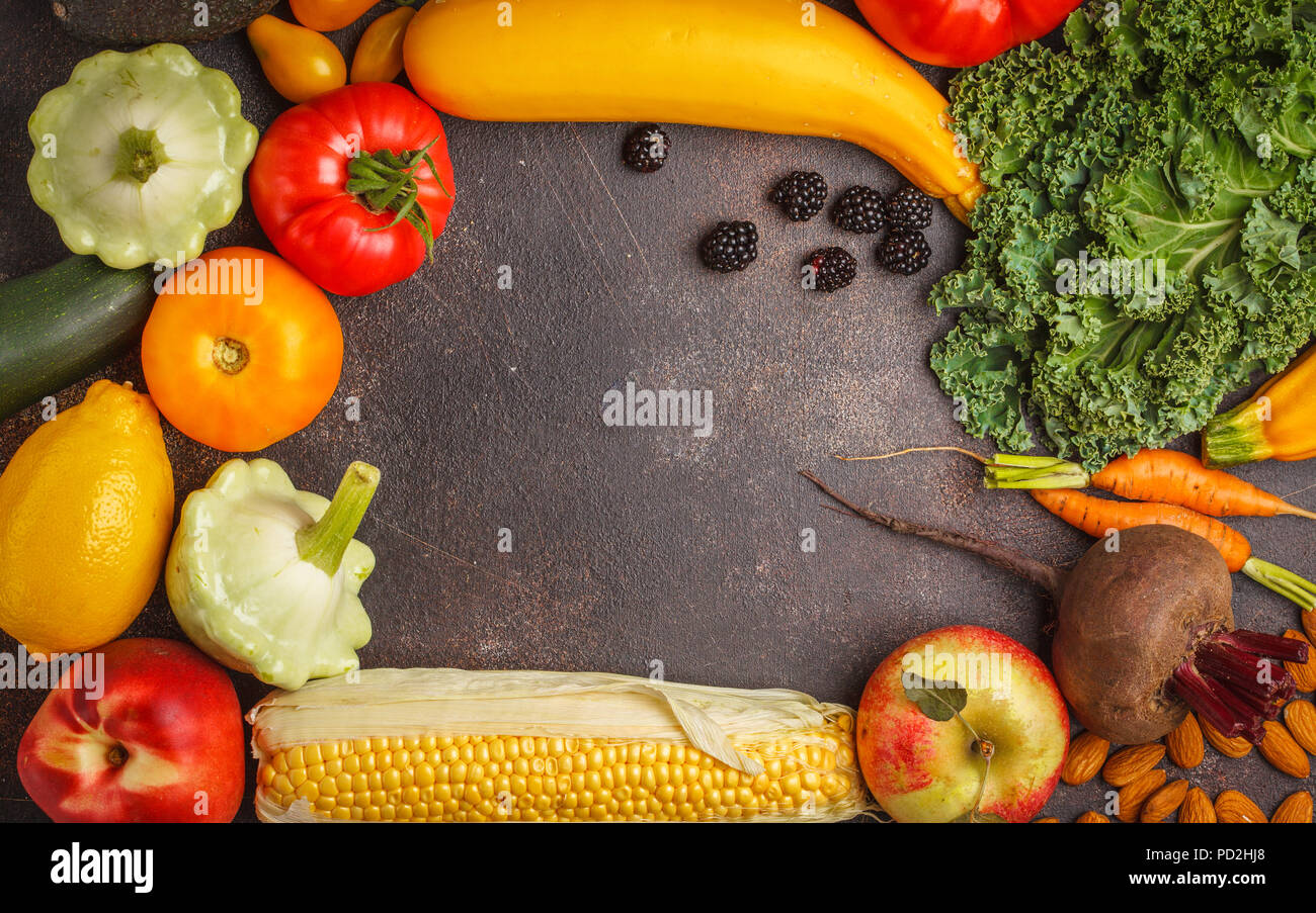 Colorati frutti, verdure e frutti di bosco su uno sfondo scuro. Pulire il concetto di mangiare, cibo vegan sfondo. Foto Stock