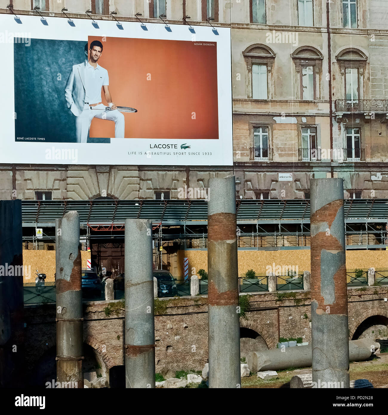 Lacoste cartellone pubblicitario su un edificio ponteggio durante i lavori di restauro, presso i Mercati di Traiano Forum. Roma, Italia. Il nuovo e il vecchio concetto di contrasto. Foto Stock