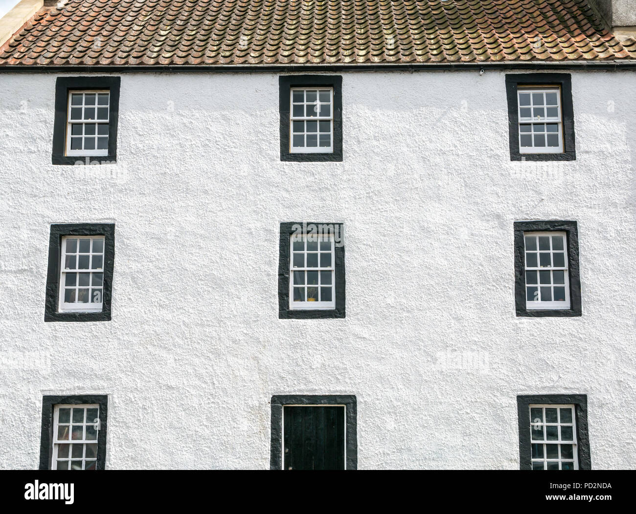 Dipinto di bianco antico casamento con tetto pantile e simmetrici righe di anta e caso a Windows, Cramond, Edimburgo, Scozia, Regno Unito Foto Stock