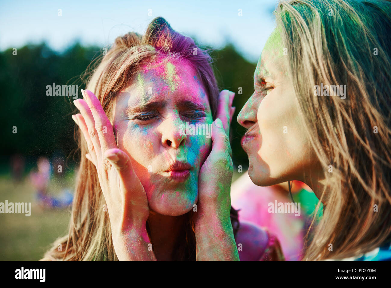 Due giovani donne con facce ricoperte in gesso colorato in polvere in Holi festival Foto Stock